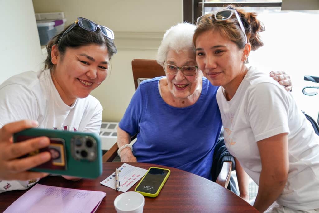 Myra Shapiro, center, poses for a photo with Bi Biheer, left, Aizhan Sardar