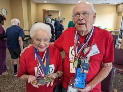 Seniors displaying medals from the Senior Olympics